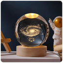 Lâmpada de cristal com galáxia iluminada, base de madeira, decoração espacial e astronauta ao fundo
