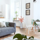 Sala de estar moderna com sofá cinza, cadeiras brancas e verdes, plantas e decoração minimalista