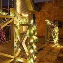 Guirlanda luminosa com folhas verdes decorando varanda à noite, ideal para festas e ambientes externos