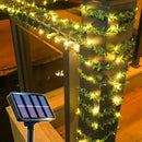 Guirlanda solar com folhas e luzes quentes decorando varanda à noite, ideal para jardim e festas ao ar livre