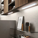 Luz LED sob armário moderna iluminando cozinha com prateleiras e decoração minimalista