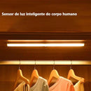 Luz inteligente com sensor de movimento para armário, iluminando roupas em cabides